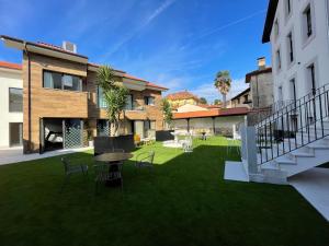 a yard with chairs and a table in a building at Apartamentos Las Indianas in Nueva de Llanes