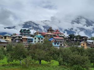eine Gruppe von Häusern vor einem Berg in der Unterkunft Wanderers Homestay -All mountain facing rooms in Kalpa