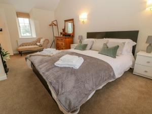 a bedroom with a large bed with towels on it at Halfpenny Cottage in Lechlade
