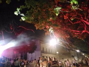 a crowd of people standing in front of a building at night at Studio vue château 100m étang, plage et halles in Mèze