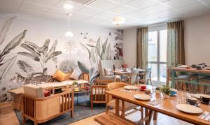 a dining room with a mural of plants on the wall at Residhome Chartres in Chartres