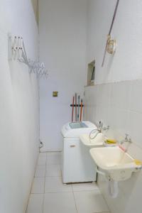 a white bathroom with a sink and a toilet at Vila Ebert in Niterói