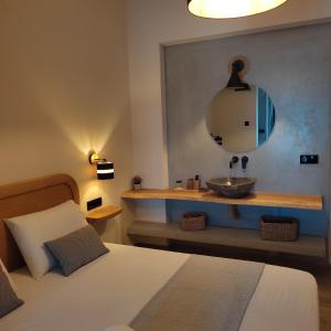 a bedroom with a bed with a sink and a mirror at Pansion Nikos in Patitiri