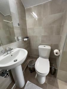 a bathroom with a white toilet and a sink at Sun's Suites in Asprovalta +12 photos