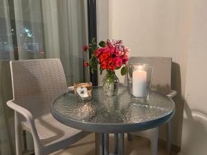 a table with a candle and a vase with flowers on it at Sun's Suites in Asprovalta