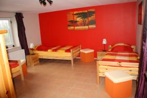 クラネンブルクにあるFerienwohnung Peerenboomshofの赤い壁の客室で、ベッド2台が備わります。