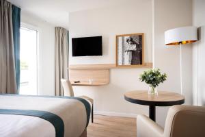 a hotel room with a bed and a table and a tv at Residhome Chartres in Chartres +21 photos