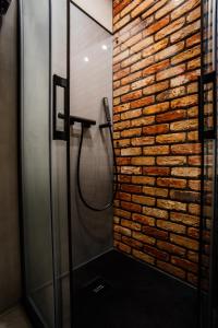 a bathroom with a brick wall and a shower at Apartament Piastowska No.6 in Olsztyn