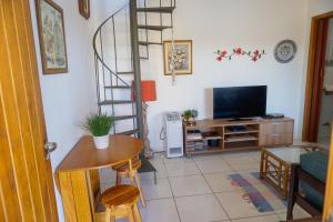 uma sala de estar com uma escada em espiral e uma televisão em Vila Ebert em Niterói