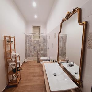 a bathroom with a sink and a large mirror at A un Passo dal Tramonto in Marsala