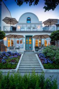 una casa con una escalera que conduce a ella con sombrillas en Kapitaenshaus in Wasserlage! Traumapartments Warnemuende en Warnemünde