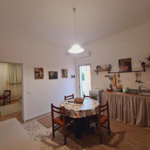 a room with a table and chairs and a kitchen at A un Passo dal Tramonto in Marsala