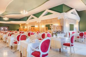 a dining room with white tables and red chairs at Iberostar Bahia - All Inclusive in Praia do Forte