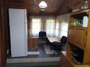 Cabana Taul Brazilor في Roşia Montană: مطبخ مع حوض وكراسي في الغرفة