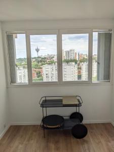 um quarto com uma mesa em frente a três janelas em Appartement 3 pièces avec parking couvert gratuit. em Le Pré-Saint-Gervais