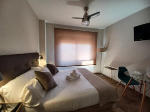 - une chambre avec un grand lit blanc et un ventilateur de plafond dans l'établissement Apartamento Luxury Triana-Los Remedios, à Séville