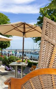 a table with an umbrella and two chairs at Kapitaenshaus in Wasserlage! Traumapartments Warnemuende in Warnemünde