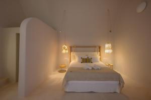 a bedroom with a large bed with two lamps at Elements Cave Suites in Megalokhori