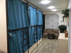 a room with blue curtains and a couch at Bonvenon capsule Hostel in Yerevan