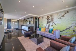 sala de estar con 2 sofás y cocina en Manhattan Towers 506 by CTHA, en Ciudad del Cabo