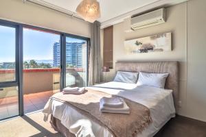 1 dormitorio con cama y ventana grande en Manhattan Towers 506 by CTHA, en Ciudad del Cabo