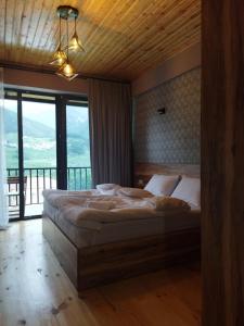 a bedroom with a large bed with a large window at Best view Kazbegi in Stepantsminda
