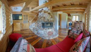 a living room with a large stone fireplace in a cabin at Natur apartma Rudi in Begunje na Gorenjskem