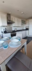 a kitchen with a wooden table with plates on it at The Property Parlour in Reading