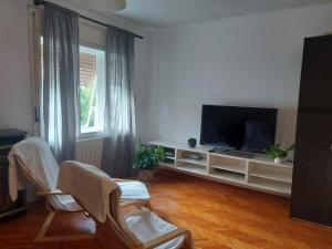 a living room with a flat screen tv and chairs at Apartment Iva Pula in Banjole