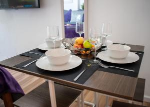 a table with two plates and a bowl of fruit at 121 Studio - Central Studio Apartment, Terrace & Full Kitchen - Airport & Train Shuttle in Bishops Stortford