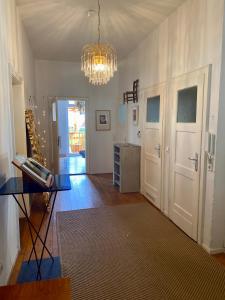 a living room with a glass table and a chandelier at Kläve12 Guesthouse in Oldenburg