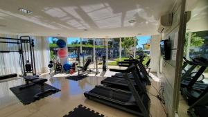 een fitnessruimte met loopbanden en crosstrainers bij Nautilus Apartment Vista Mar in Penha