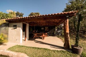 Casa de campo com piscina cascata artificial في ساو لورينسو: بريغولا خشبي تحته طاولة نزهة