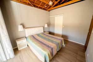 um pequeno quarto com uma cama e um tecto em madeira em Casa de campo com piscina cascata artificial em São Lourenço