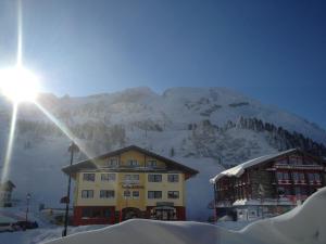 un edificio nella neve con una montagna sullo sfondo di Hotel-Skischule Krallinger a Obertauern