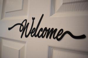 eine Tür mit dem Wort "Willkommen" darauf geschrieben in der Unterkunft 121 Studio - Central Studio Apartment, Terrace & Full Kitchen - Airport & Train Shuttle in Bishops Stortford