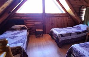 a attic room with two beds and a window at Neli Maria in Villa Pehuenia