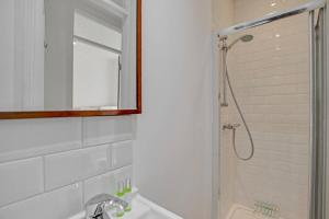 a bathroom with a shower and a sink and a mirror at Flat C, Old Street in London