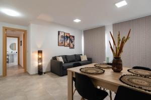 sala de estar con mesa y sofá en Nuevo y moderno apartamento con aire acondicionado - El Cid 4, en Burriana