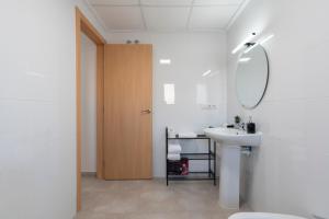 ein weißes Badezimmer mit Waschbecken und Spiegel in der Unterkunft Nuevo y moderno apartamento con aire acondicionado - El Cid 4 in Burriana + 11 Fotos