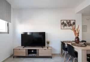 sala de estar con TV y mesa en Nuevo y moderno apartamento con aire acondicionado - El Cid 4, en Burriana