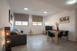 ein Wohnzimmer mit Sofa und Tisch in der Unterkunft Nuevo y moderno apartamento con aire acondicionado - El Cid 4 in Burriana