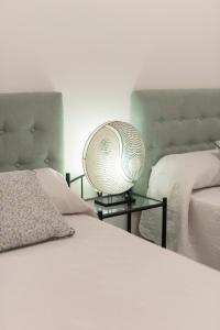 ein Schlafzimmer mit 2 Betten und einer Lampe auf einem Tisch in der Unterkunft Nuevo y moderno apartamento con aire acondicionado - El Cid 4 in Burriana