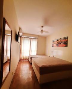 ein Hotelzimmer mit 2 Betten und einem Spiegel in der Unterkunft Guarujá Astúrias in Guarujá