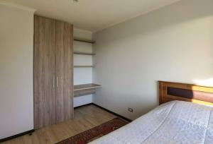 een slaapkamer met een bed en een houten kast bij CASA EN ALTAS CUMBRES DE PINGUERAL in Concepción