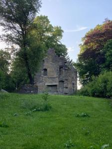 un antiguo edificio de piedra en un campo de hierba en 2 bed flat in Moray, near coast and Whisky Trail, en Keith