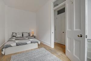 um quarto branco com uma cama e uma porta em Flat C, Old Street em Londres