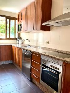 a kitchen with wooden cabinets and a stainless steel appliance at Albatros Golf View 2394 in Casares