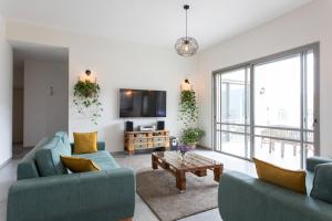 un soggiorno con due divani blu e una TV di Our Mount Meron Orchard - your perfect getaway a Tsiv'on