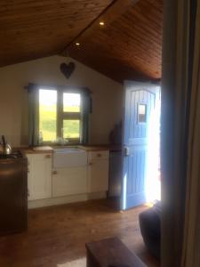a kitchen with a blue door and a window at Croft B&B Accommodation With Hot Tub in Gamrie